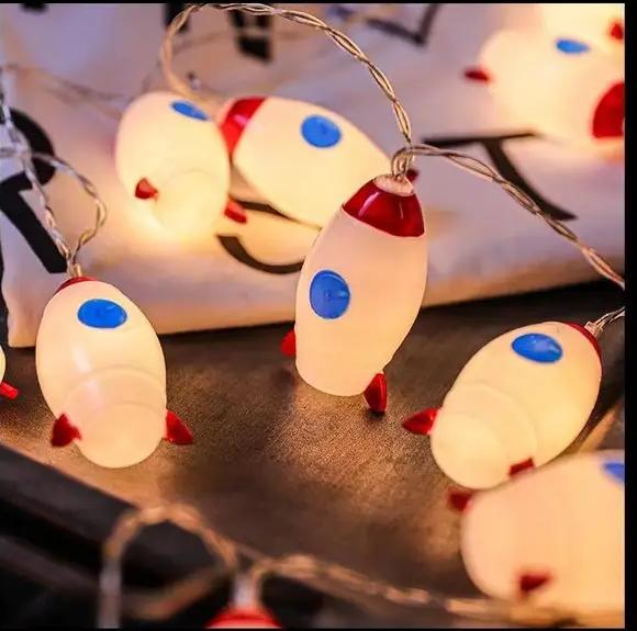 "LED Rocket String Lights featuring 10 rocket-shaped LED lights, USB & battery operated, perfect for room décor, parties, and children's rooms. Creative and fun lighting for any space."